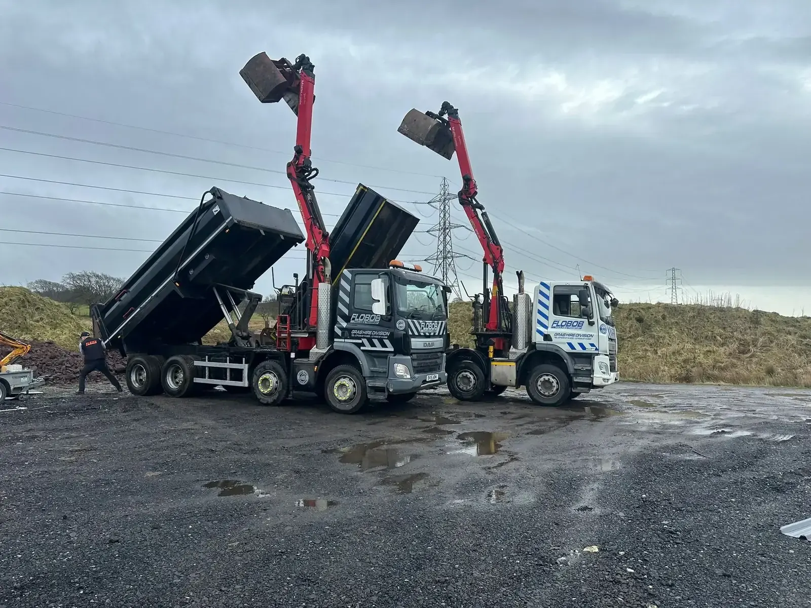 Grab Hire Scotland's dark-grey grab trucks with red cranes, ready for work